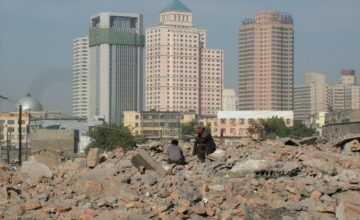 A Uyghur man and boy sit on the rubble of their destroyed homes in Urumqi in an undated photo. Photo courtesy of RFA listener