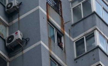 Guzailai Nu'er, the wife of Ilham Tohti, conducts an interview with Reuters by a phone from window of her house in Beijing, January 17, 2014. (Photo: Kim Kyung-Hoon / Reuters)