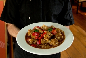 Silk Road Uyghur Cuisine chef Rizaydn Reyim with his dish, spicy lamb feet. Photo / Brett Phibbs