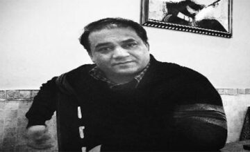 Tohti has been held incommunicado since January 15; (top) Guzailai Nu'er, his wife, gives an interview to Reuters on a phone from the window of her house in Beijing. Photo: Reuters